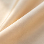 Nahaufnahme der Maulbeerseide in Champagner, dichte glatte Oberfläche mit weichem Glanz