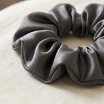 Nahaufnahme der gerafften Maulbeerseide am Scrunchie in Graphit